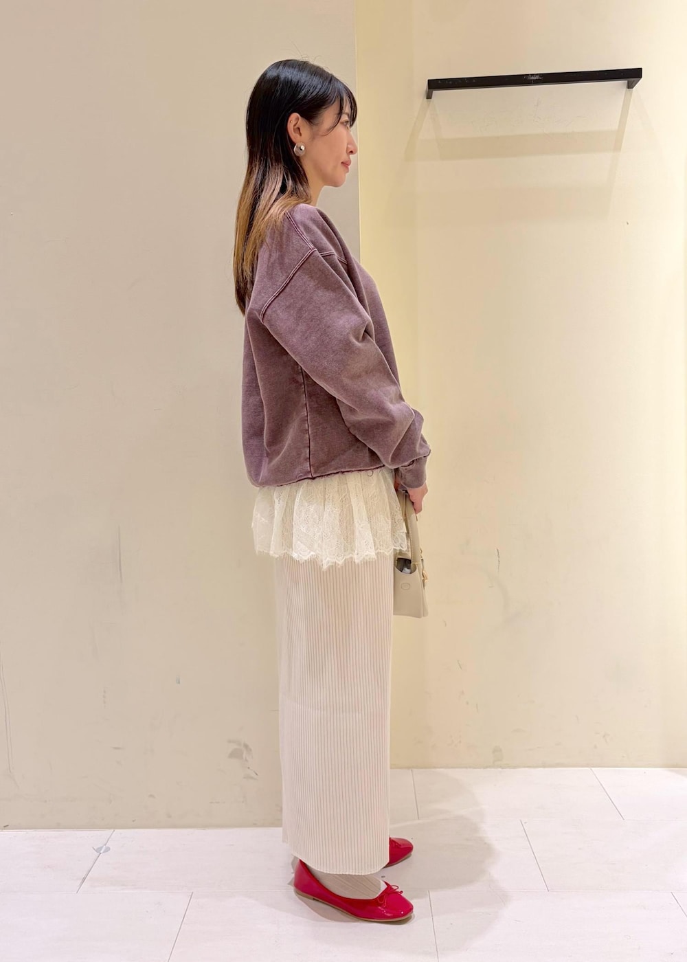 レッド系のバレエシューズ、ホワイト系のショルダーバッグ、ホワイト系のキャミソールを着用したレディースの冬コーディネートの2枚目の写真