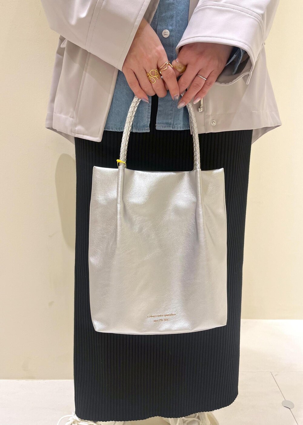 シルバー系のトートバッグ、ブラック系のスカート、ブルー系のシャツ/ブラウスを着用したレディースの春コーディネートの8枚目の写真