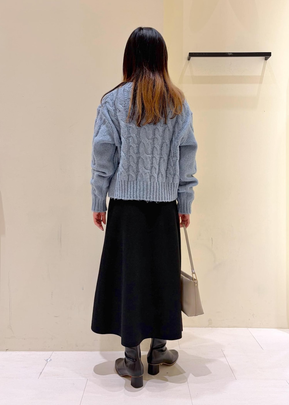 ブラック系のブーツ、ベージュ系のショルダーバッグ、ブラック系のワンピースを着用したレディースの冬コーディネートの4枚目の写真