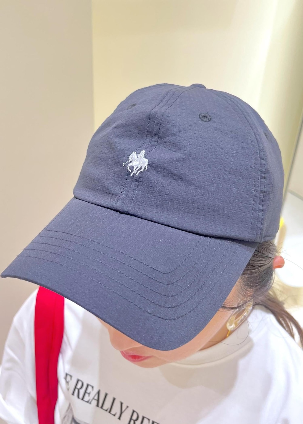 ブルー系のデニムパンツ、ホワイト系のスカート、ブラック系のサンダルを着用したレディースの夏コーディネートの5枚目の写真