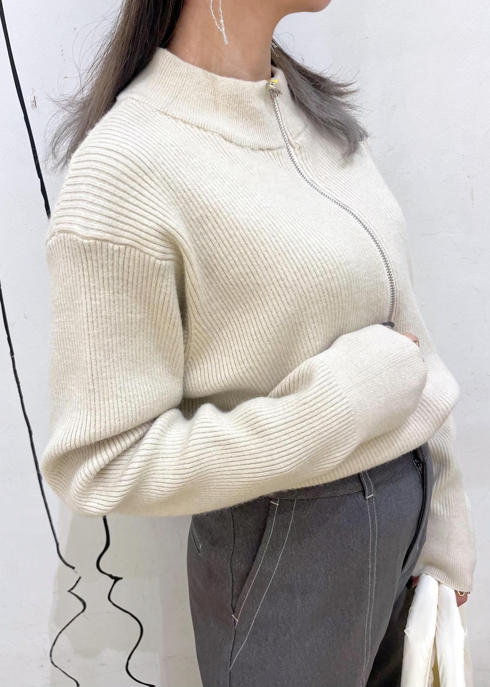 ベージュ系のニット/セーター、ホワイト系のトートバッグ、ブラック系のスリッポンを着用したレディースの冬コーディネートの5枚目の写真