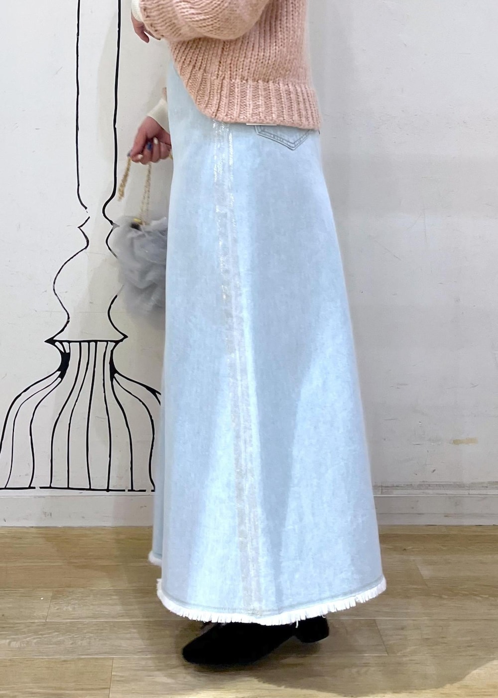 ホワイト系のニット/セーター、ブラック系のパンプス、ブルー系のデニムスカートを着用したレディースの冬コーディネートの8枚目の写真