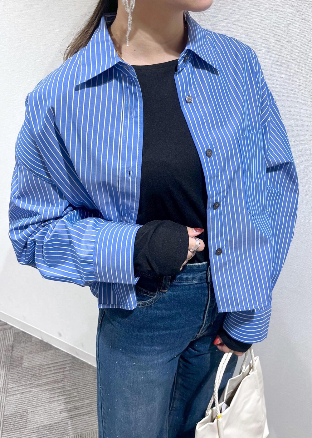 ブラック系のTシャツ/カットソー、ブラック系のローファー、ホワイト系のトートバッグを着用したレディースの冬コーディネートの4枚目の写真