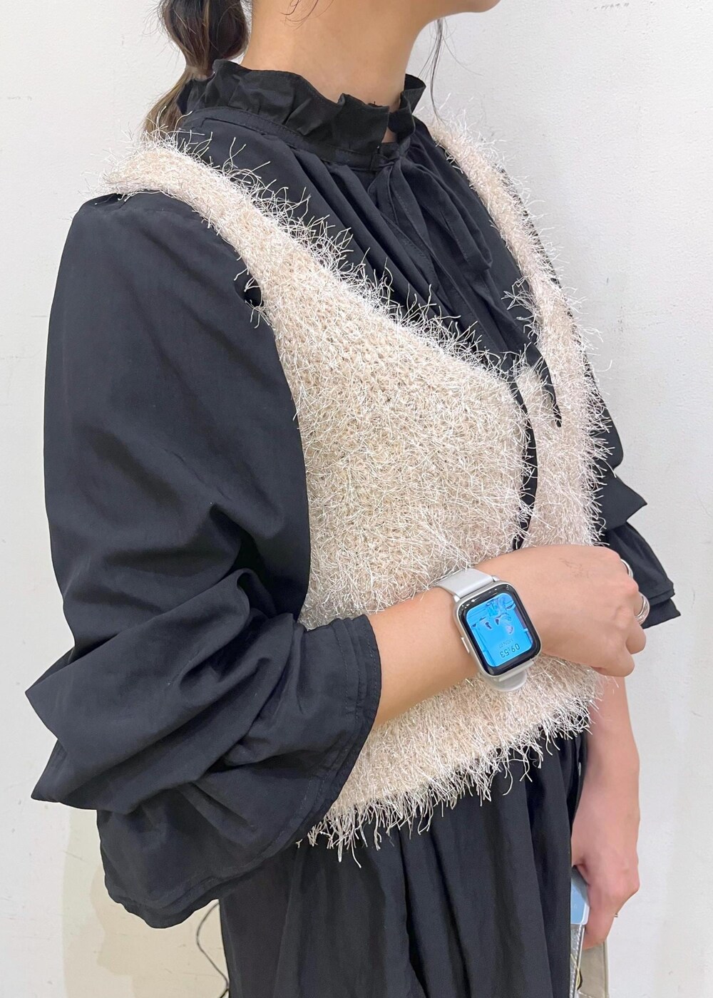 ベージュ系のスカート、ベージュ系のベスト、ブラック系のシャツ/ブラウスを着用したレディースの秋コーディネートの7枚目の写真