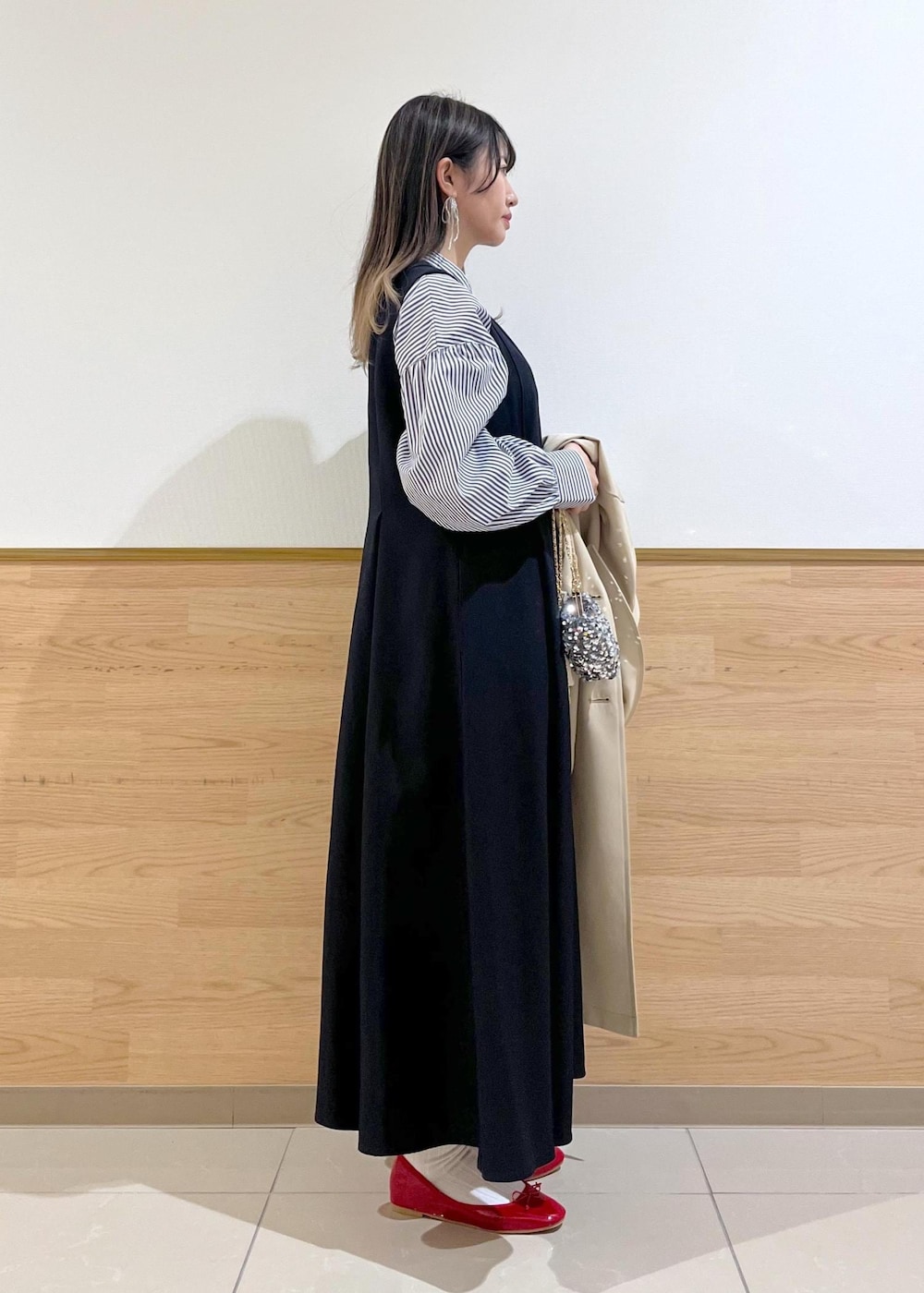 グレー系のショルダーバッグ、ブルー系のシャツ/ブラウス、ベージュ系のトレンチコートを着用したレディースの春コーディネートの4枚目の写真