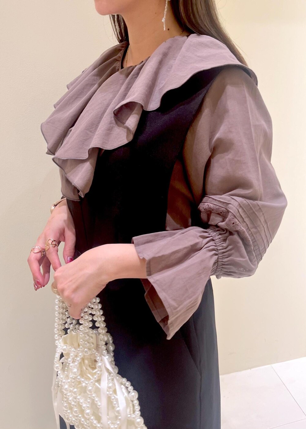 ホワイト系のバレエシューズ、ブラウン系のシャツ/ブラウス、ブラック系のジャンパースカートを着用したレディースの春コーディネートの7枚目の写真