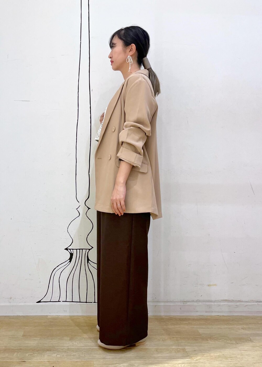 ブラック系のニット/セーター、ホワイト系のキャミソール、ベージュ系のローファーを着用したレディースの秋コーディネートの3枚目の写真