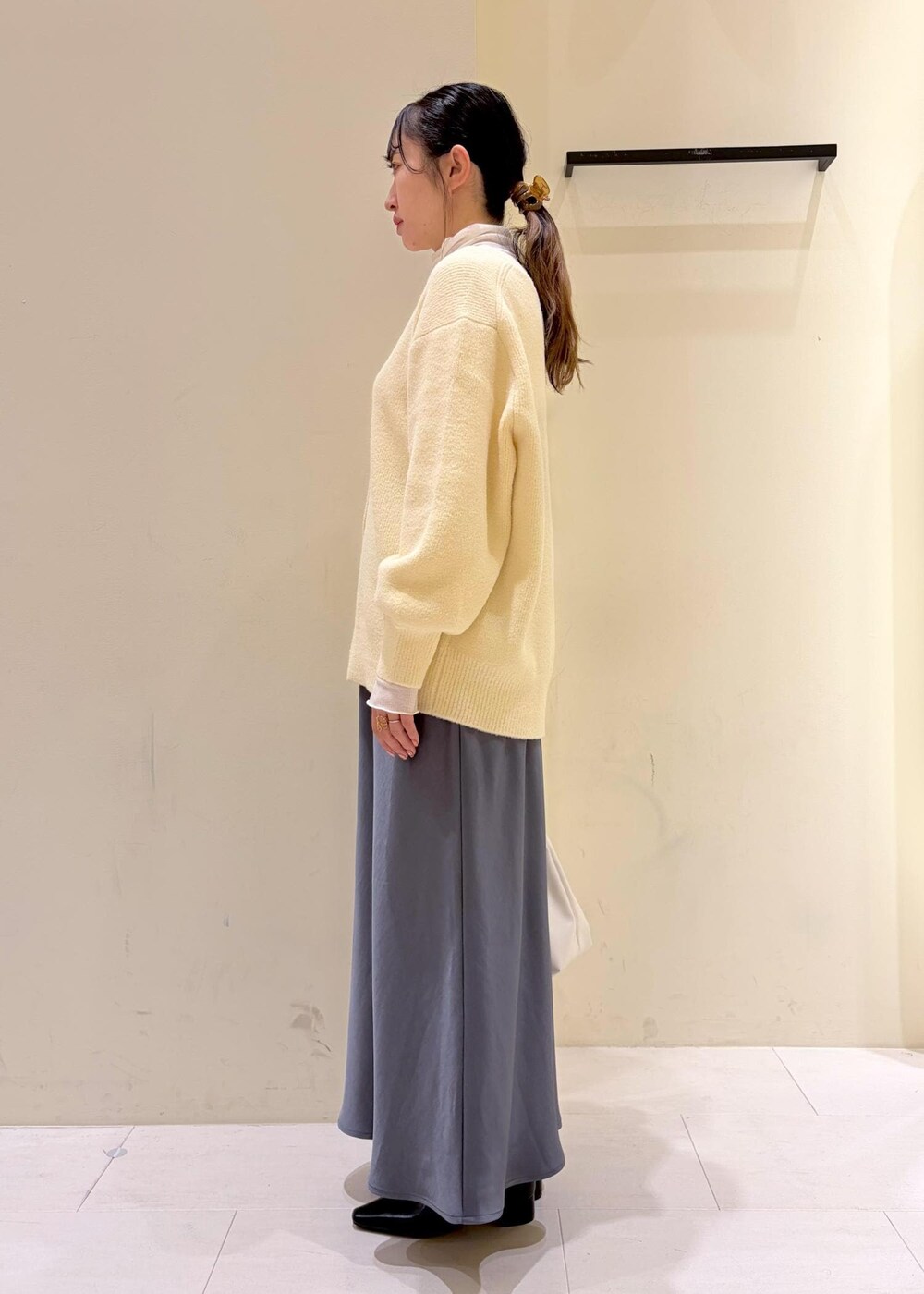 ベージュ系のカーディガン/ボレロ、ホワイト系のトートバッグ、ホワイト系のTシャツ/カットソーを着用したレディースの冬コーディネートの4枚目の写真