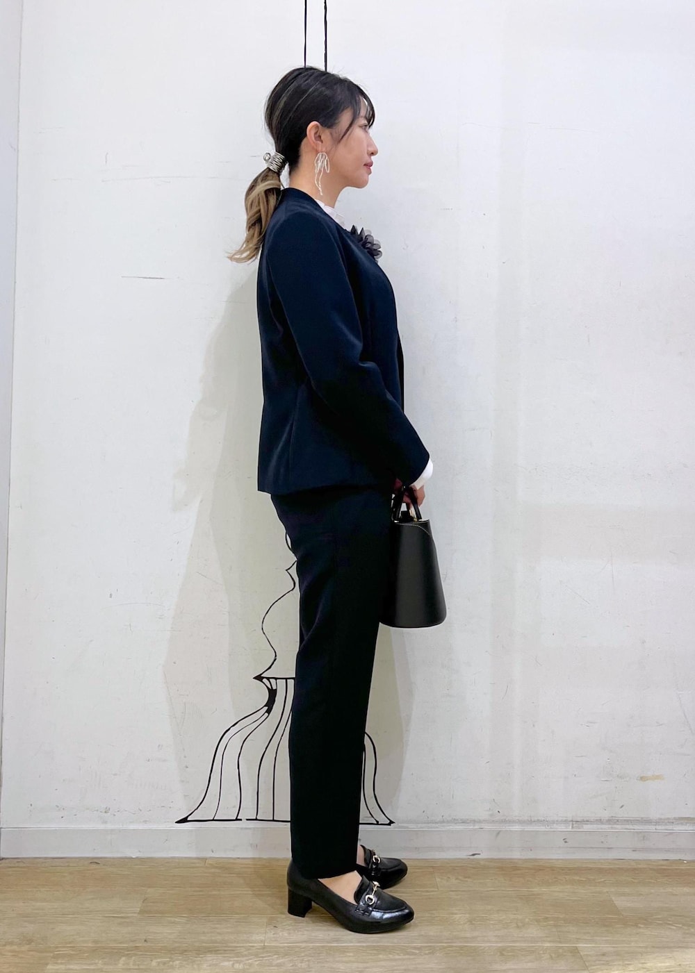 ブラック系のショルダーバッグ、ブラック系のローファー、ピンク系のシャツ/ブラウスを着用したレディースの冬コーディネートの2枚目の写真