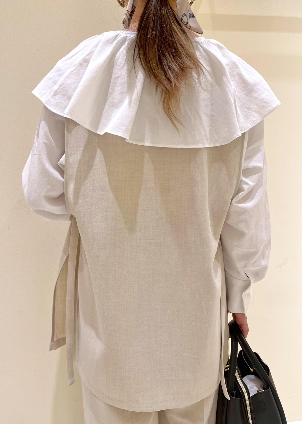 ホワイト系のシャツ/ブラウス、ベージュ系のその他パンツ、ベージュ系のベストを着用したレディースの春コーディネートの6枚目の写真