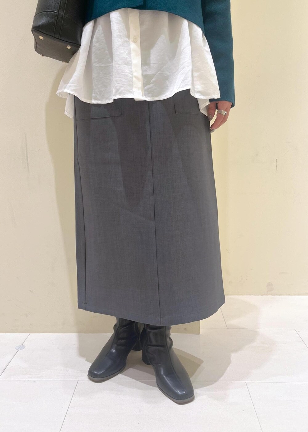 グレー系のスカート、ホワイト系のシャツ/ブラウス、グリーン系のカーディガン/ボレロを着用したレディースの秋コーディネートの8枚目の写真