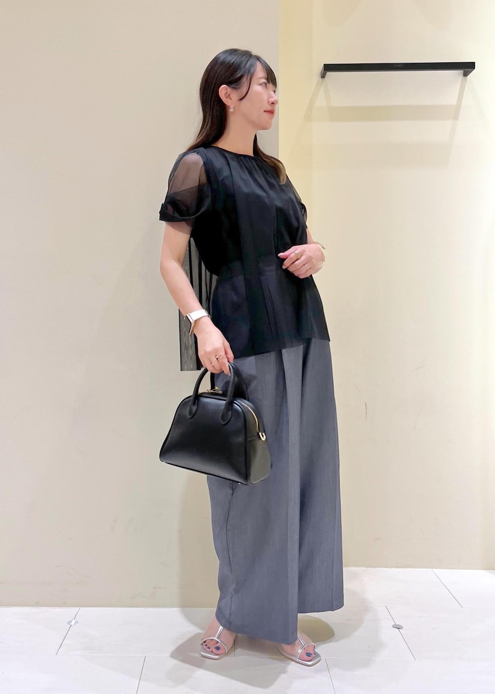ブラック系のボストンバッグ、シルバー系のパンプス、ブラック系のTシャツ/カットソーを着用したレディースの夏コーディネートの2枚目の写真