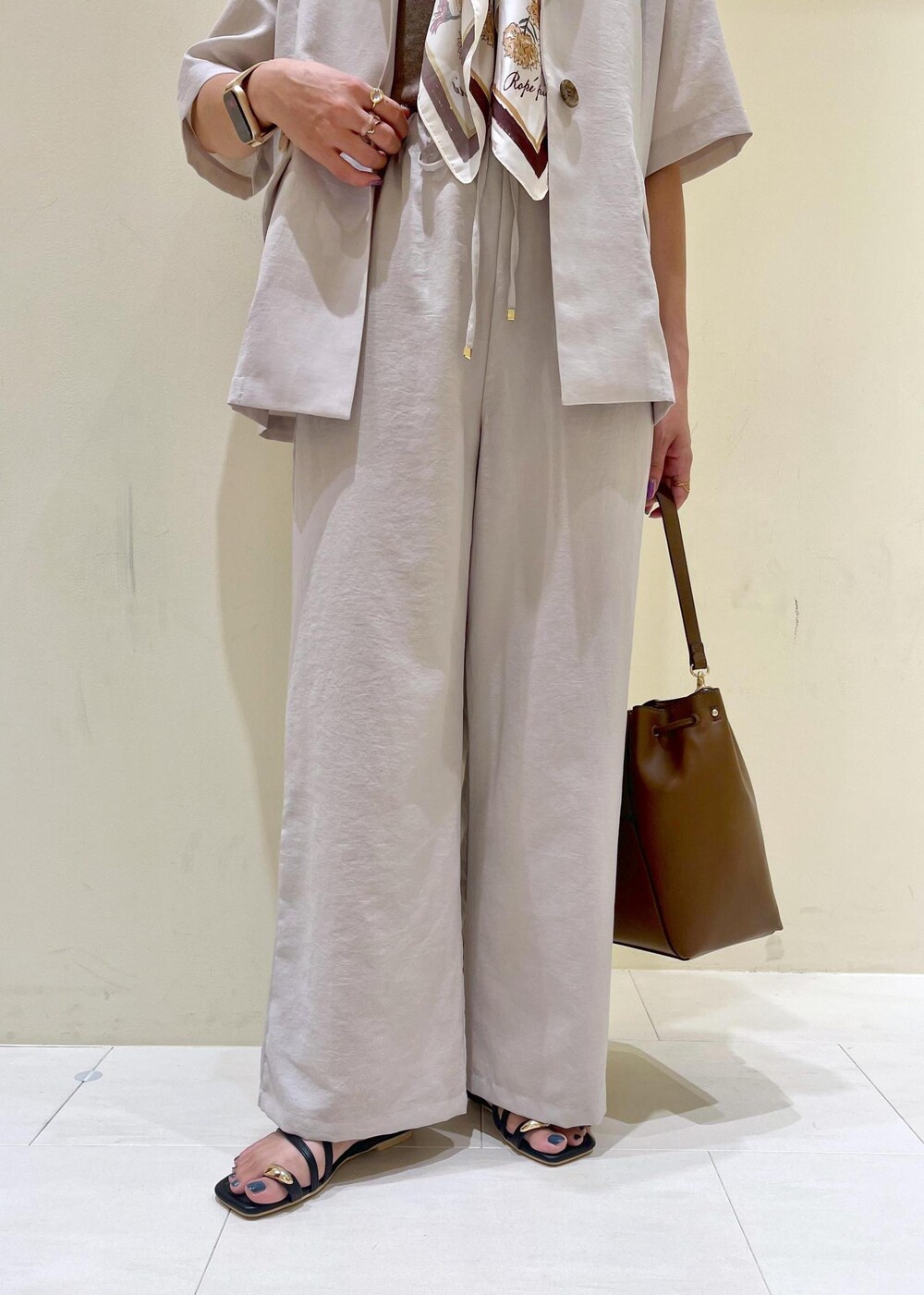 ベージュ系のテーラードジャケット、その他のニット/セーター、ブラウン系のショルダーバッグを着用したレディースの秋コーディネートの7枚目の写真