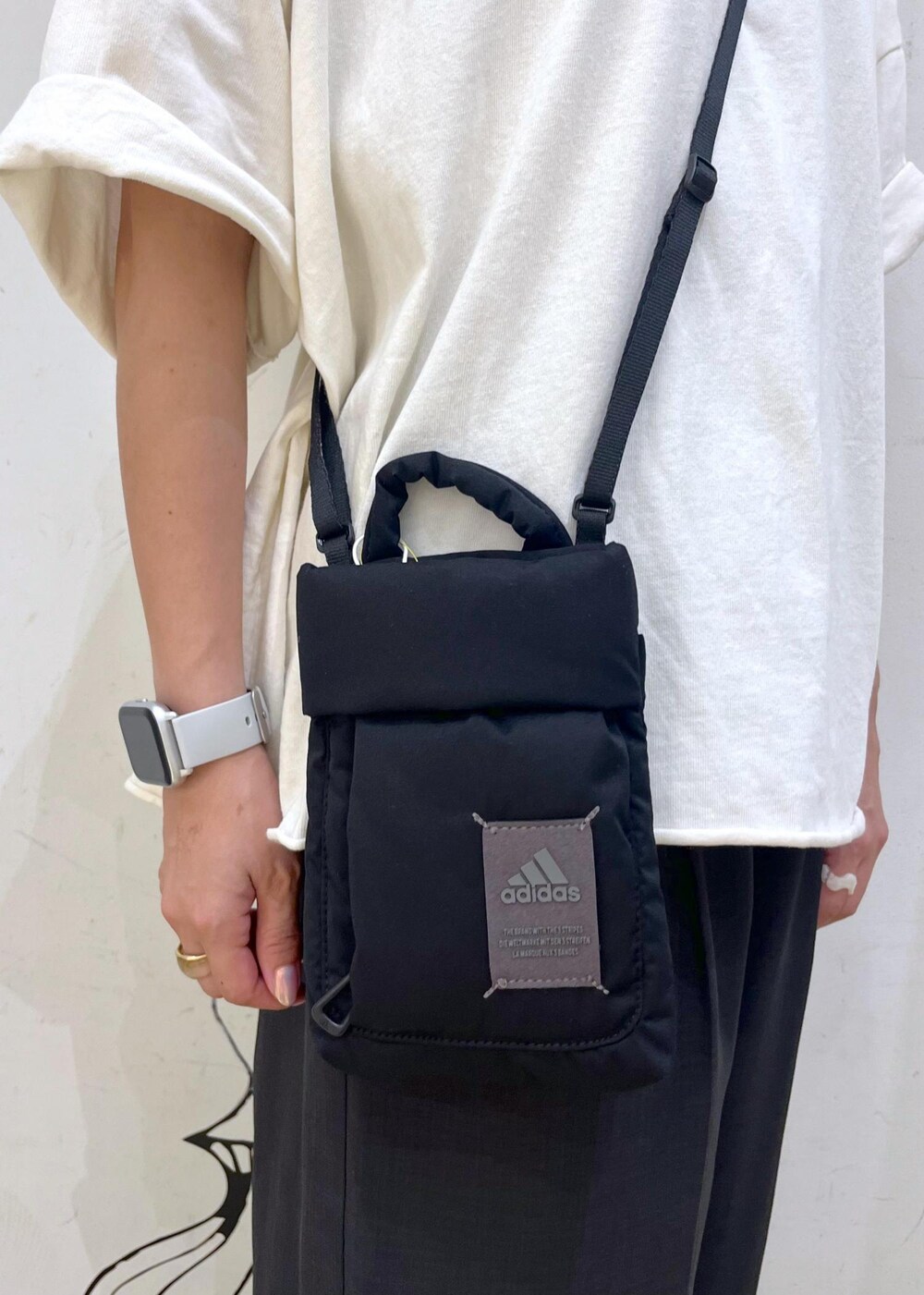 グレー系のその他パンツ、ホワイト系のTシャツ/カットソー、ブラック系のショルダーバッグを着用したレディースの夏コーディネートの8枚目の写真