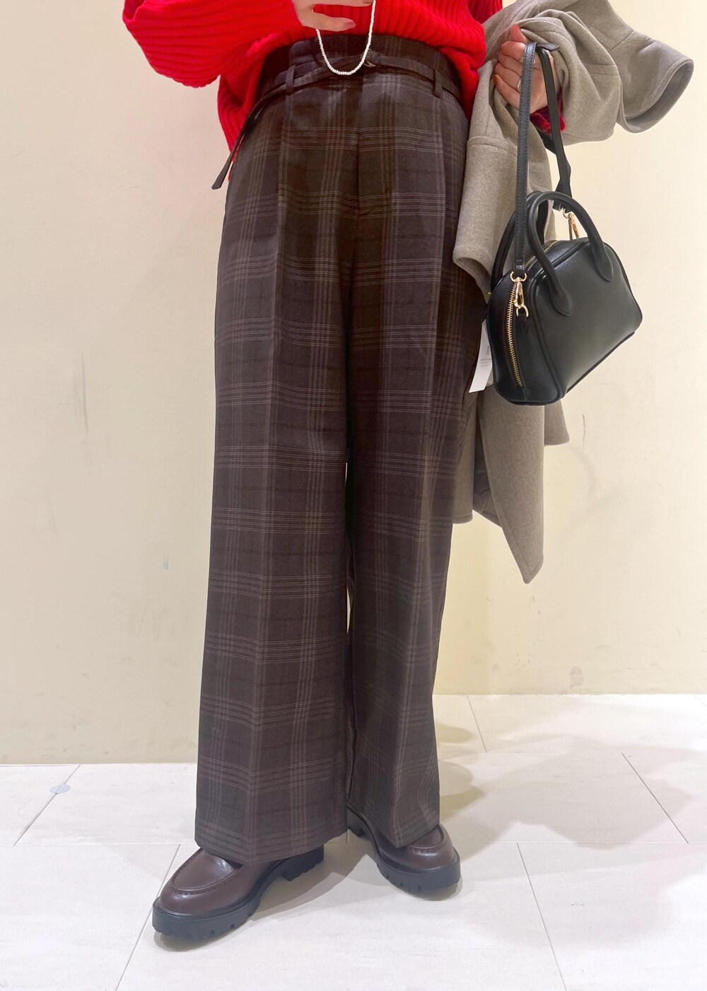 ブラック系のショルダーバッグ、レッド系のニット/セーター、ブラウン系のピーコートを着用したレディースの秋コーディネートの8枚目の写真