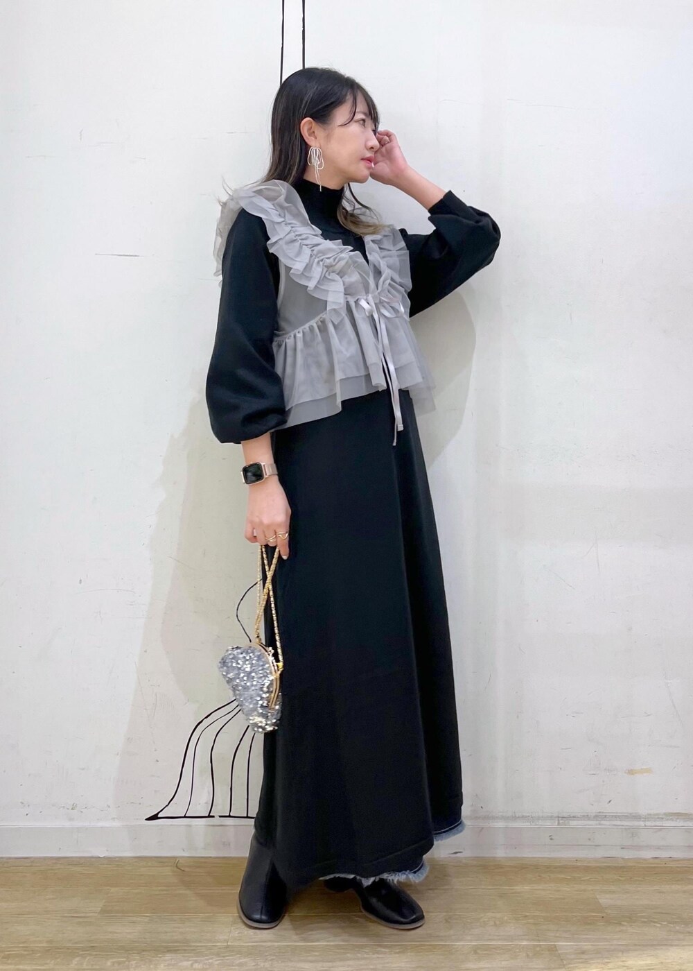 ブルー系のデニムスカート、ブラック系のブーツ、ブラック系のワンピースを着用したレディースの冬コーディネートの2枚目の写真