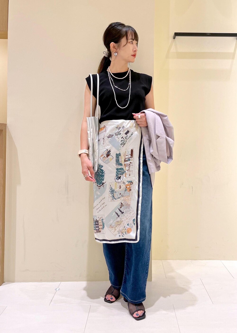 ブルー系のデニムパンツ、シルバー系のトートバッグ、ブラック系のパンプスを着用したレディースの夏コーディネートの10枚目の写真