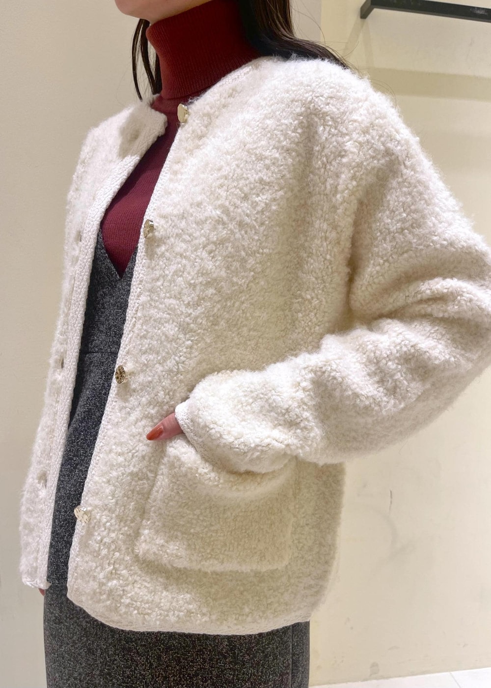 ブラック系のショルダーバッグ、ホワイト系のカーディガン/ボレロ、レッド系のニット/セーターを着用したレディースの秋コーディネートの6枚目の写真