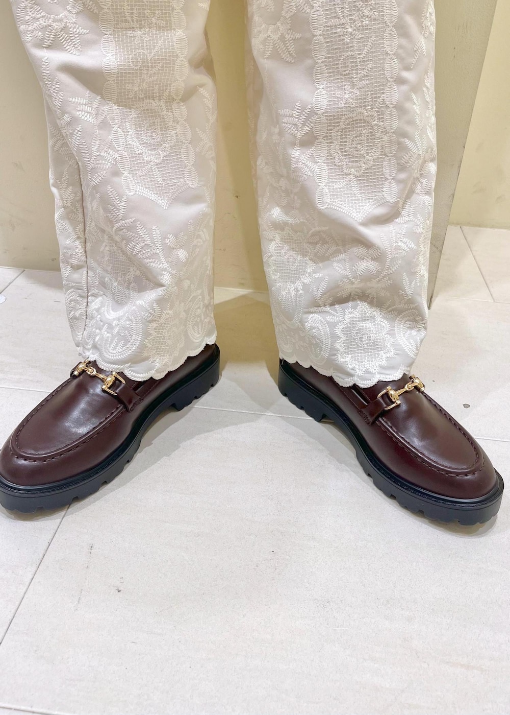 ホワイト系のニット/セーター、ブラウン系のショルダーバッグ、ブラウン系のローファーを着用したレディースの冬コーディネートの9枚目の写真