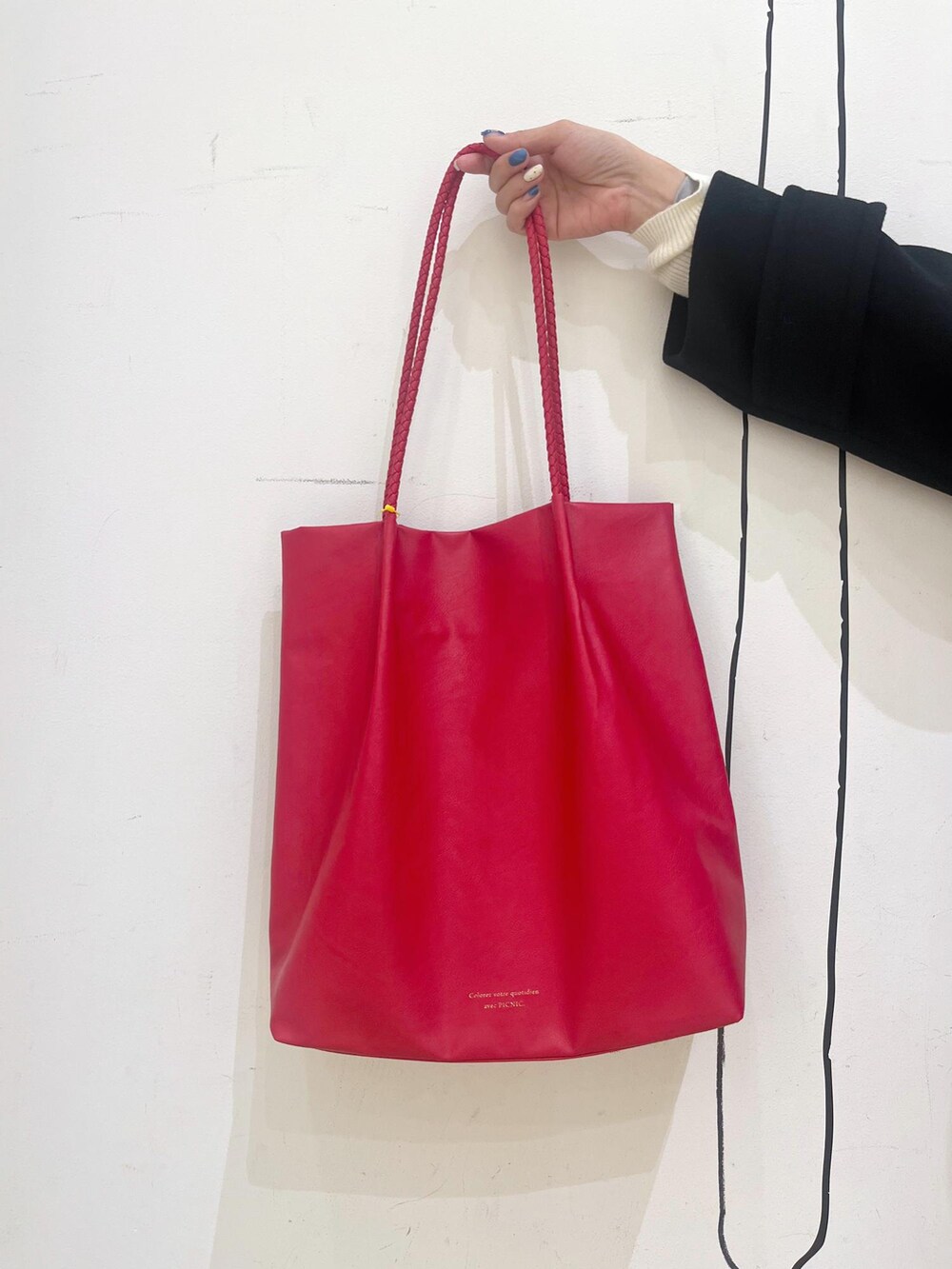 ブルー系のデニムパンツ、レッド系のトートバッグ、ブラック系のその他アウターを着用したレディースの冬コーディネートの9枚目の写真