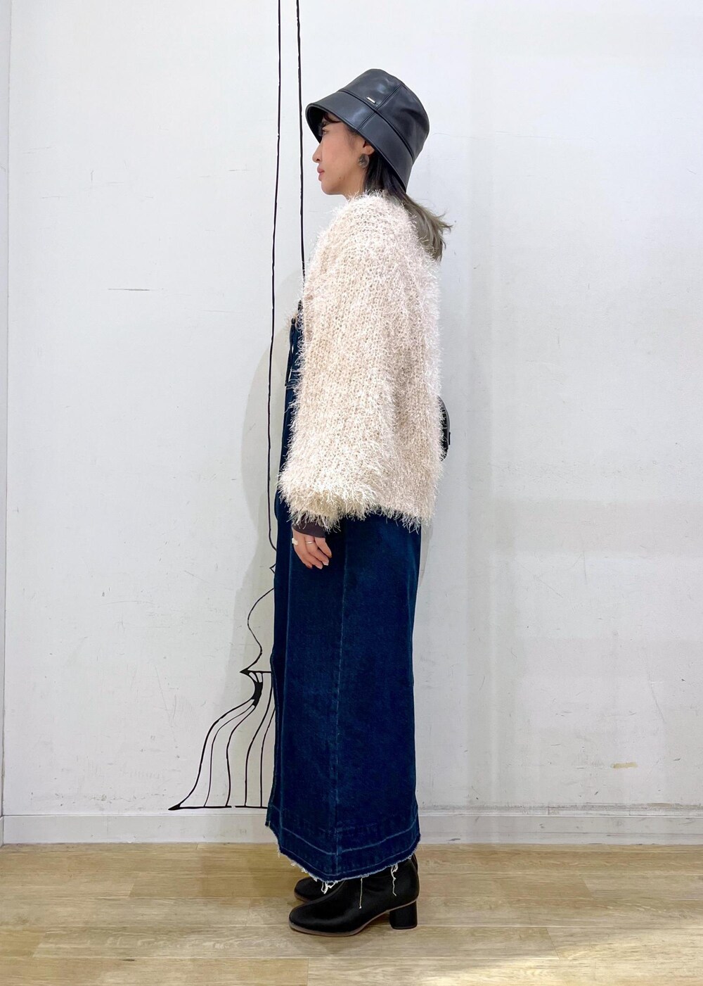 グレー系のTシャツ/カットソー、ベージュ系のカーディガン/ボレロ、ブラック系のブーツを着用したレディースの秋コーディネートの3枚目の写真