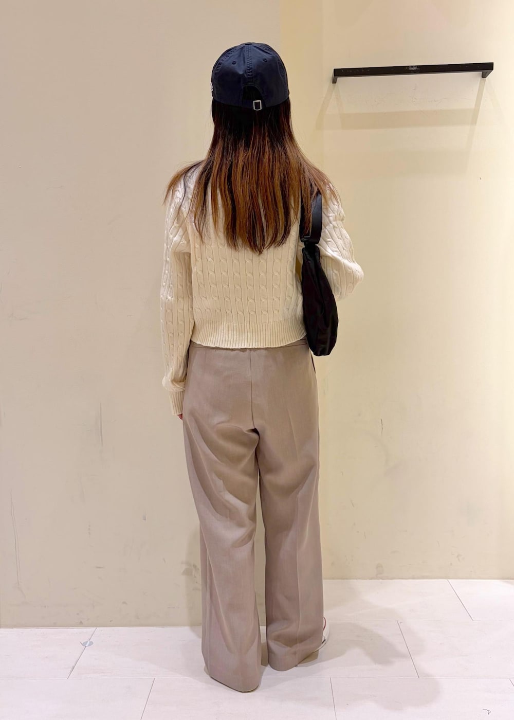 ホワイト系のニット/セーター、ベージュ系のその他パンツ、ブラック系のボディバッグ/ウエストポーチを着用したレディースの冬コーディネートの3枚目の写真