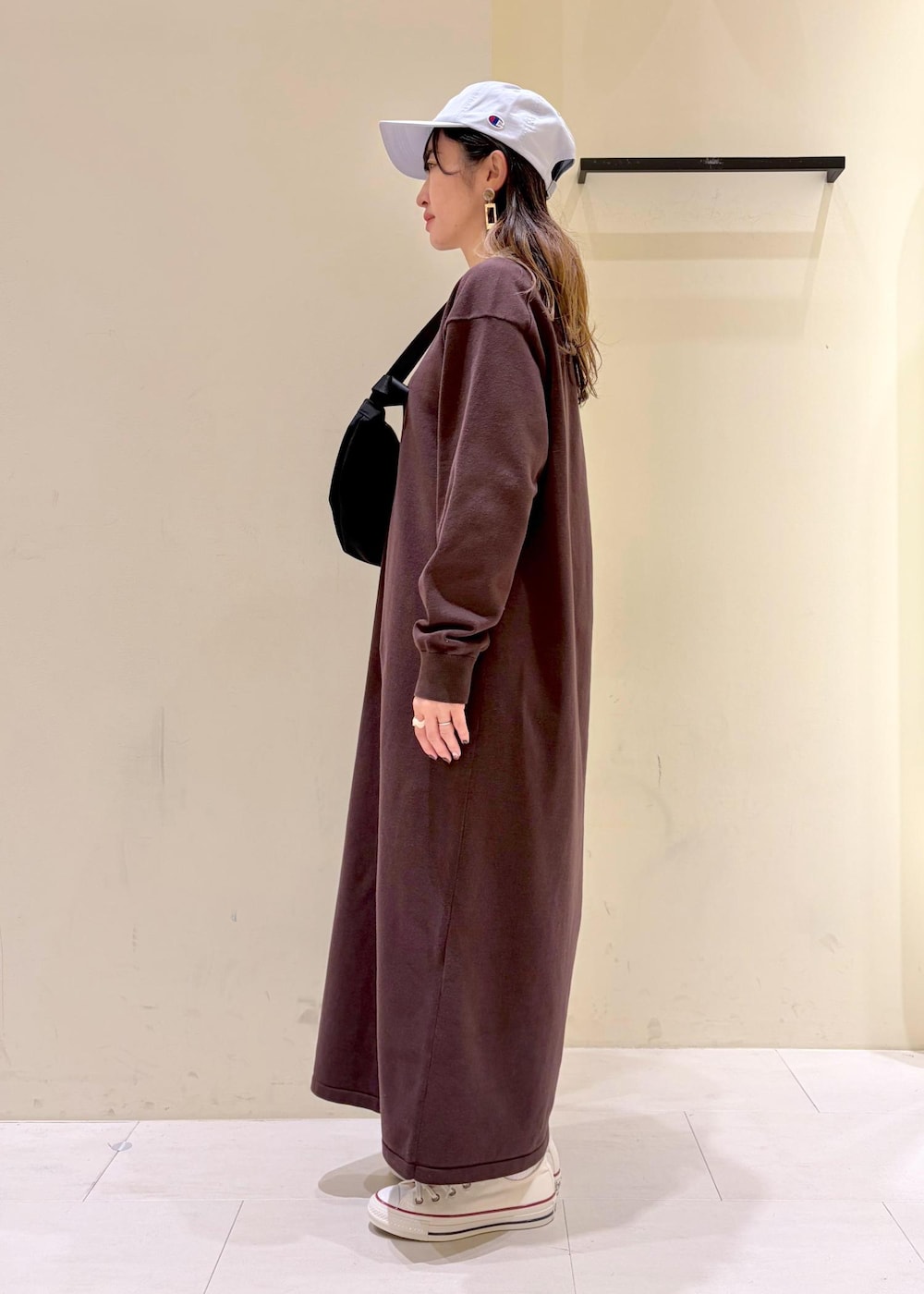 ブラウン系のワンピース、ブラック系のボディバッグ/ウエストポーチ、ホワイト系のスニーカーを着用したレディースの冬コーディネートの4枚目の写真