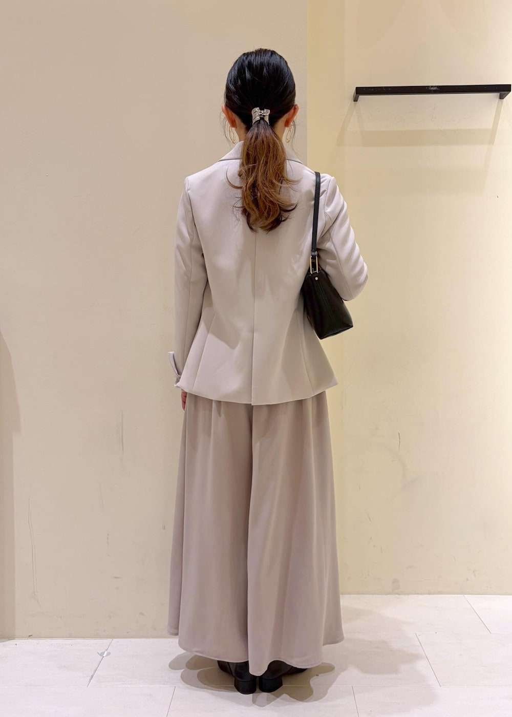 ベージュ系のその他パンツ、ブラック系のショルダーバッグ、グレー系のテーラードジャケットを着用したレディースの冬コーディネートの3枚目の写真