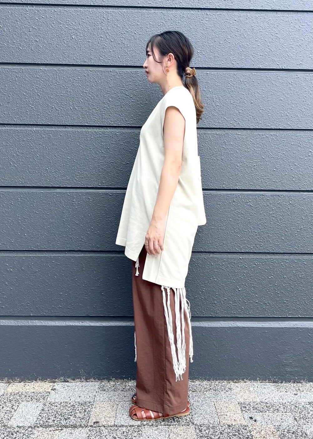ホワイト系のトートバッグ、ホワイト系のスカート、ブラウン系のその他パンツを着用したレディースの夏コーディネートの5枚目の写真