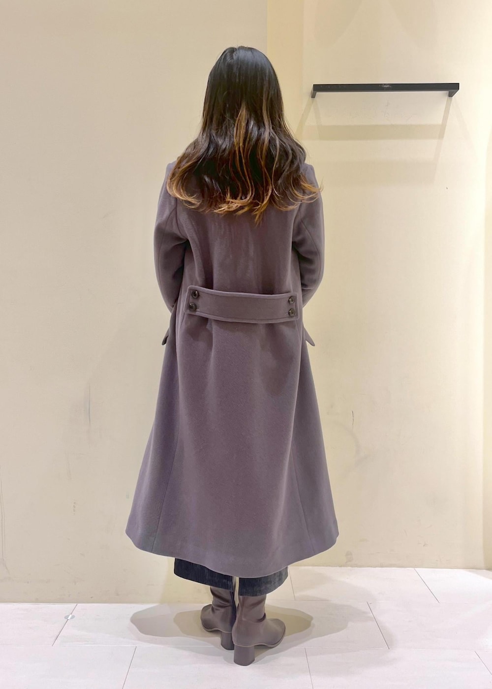 ホワイト系のニット/セーター、グレー系のチェスターコート、レッド系のショルダーバッグを着用したレディースの冬コーディネートの4枚目の写真