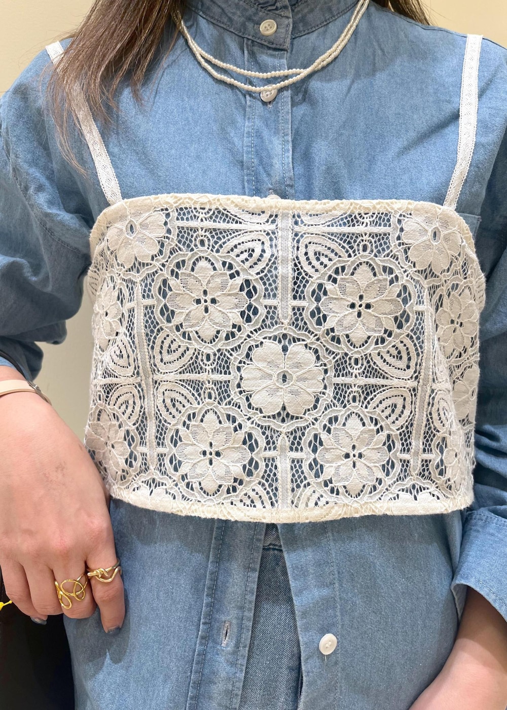 ブルー系のデニムパンツ、ホワイト系のキャミソール、ブラック系のハンドバッグを着用したレディースの春コーディネートの6枚目の写真