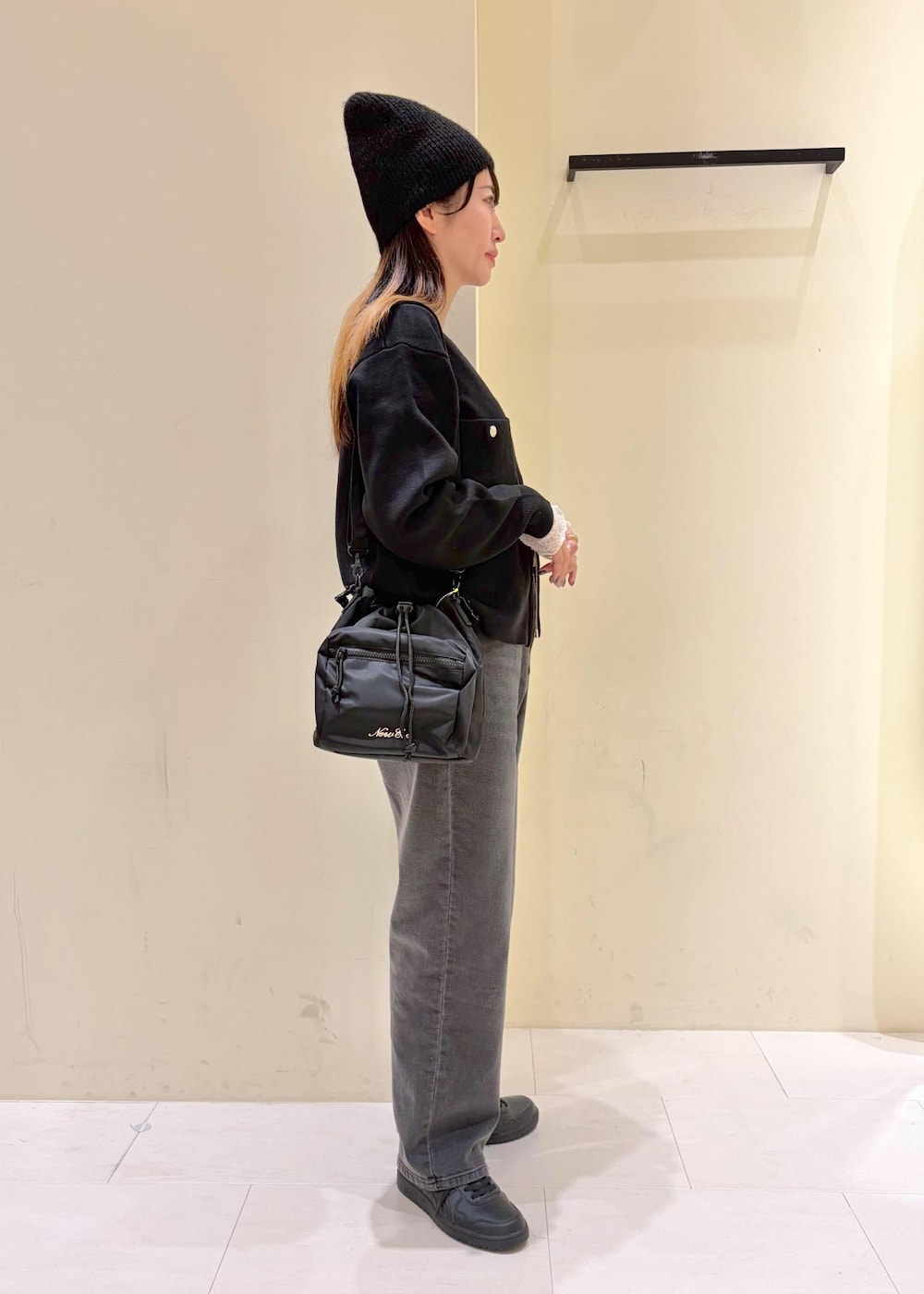 ホワイト系のTシャツ/カットソー、ブラック系のカーディガン/ボレロ、ブラック系のデニムパンツを着用したレディースの春コーディネートの4枚目の写真