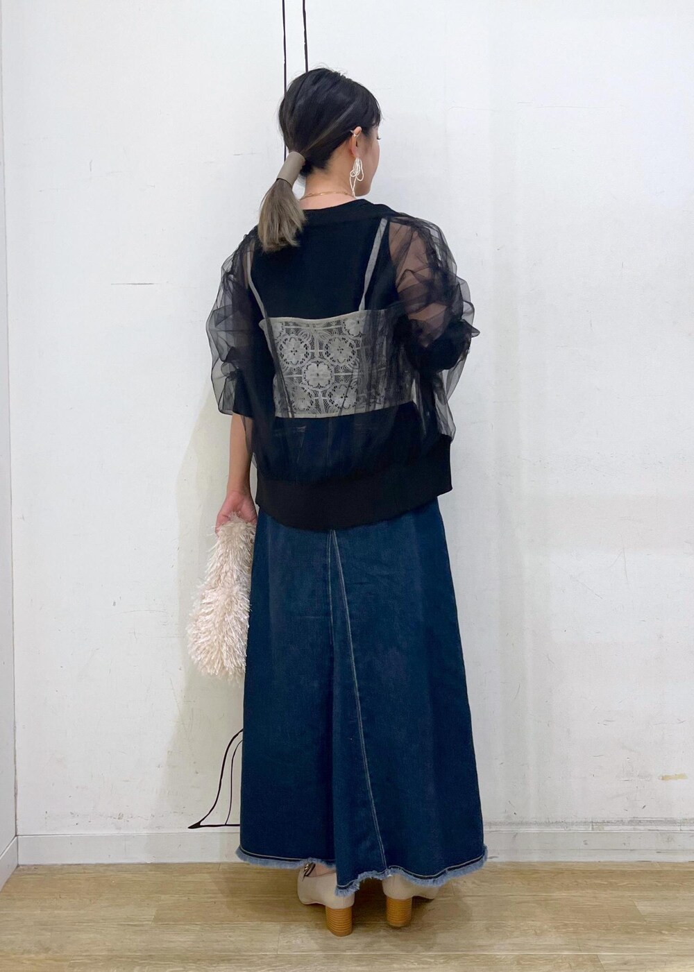 ベージュ系のタンクトップ、ホワイト系のキャミソール、ベージュ系のハンドバッグを着用したレディースの秋コーディネートの5枚目の写真