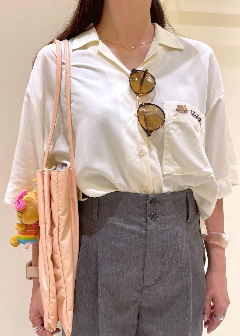 ピンク系のトートバッグ、グレー系のチノパンツ、ホワイト系のシャツ/ブラウスを着用したレディースの夏コーディネートの5枚目の写真