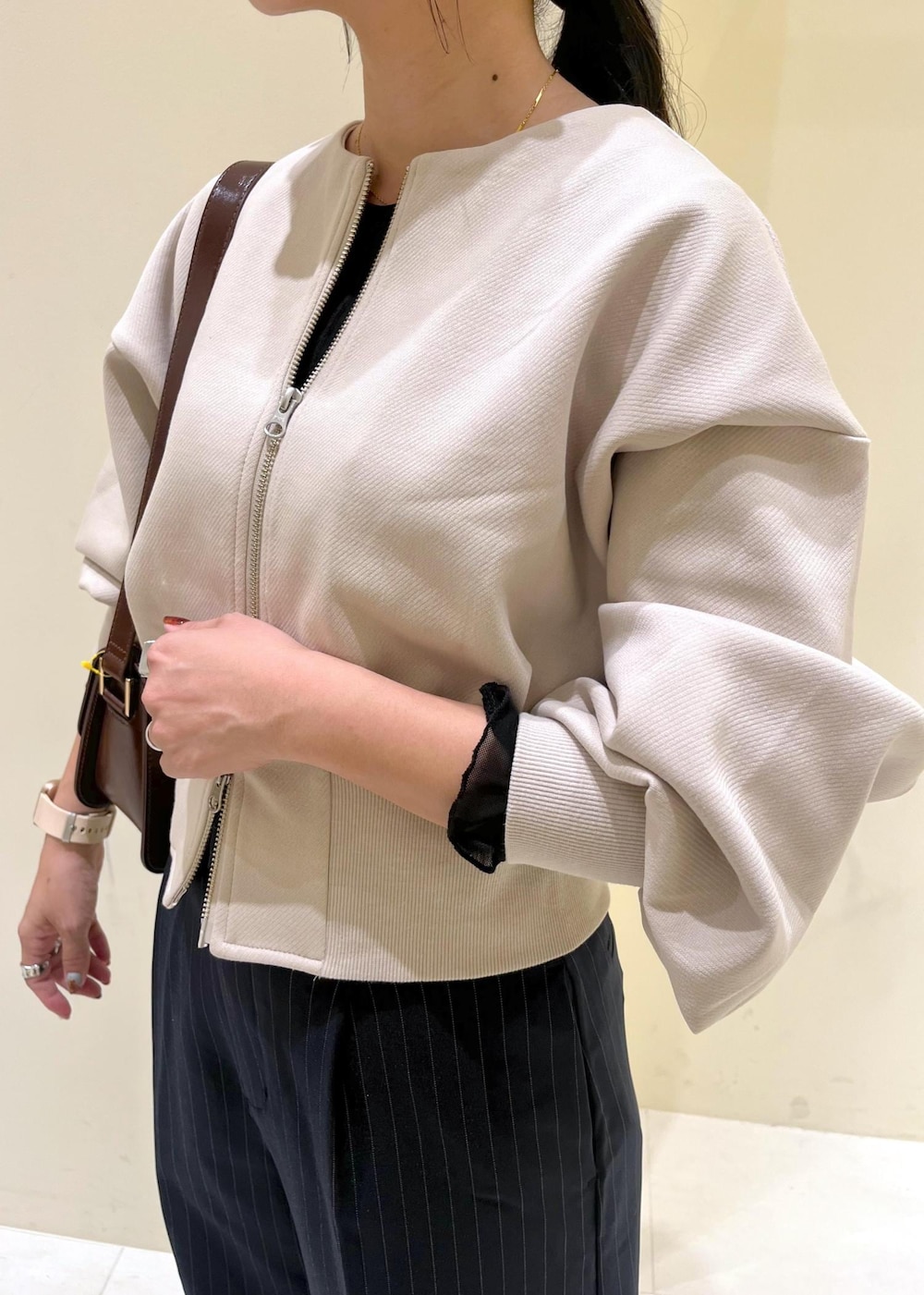 レッド系のショルダーバッグ、ブルー系のその他パンツ、ブラック系のTシャツ/カットソーを着用したレディースの秋コーディネートの6枚目の写真