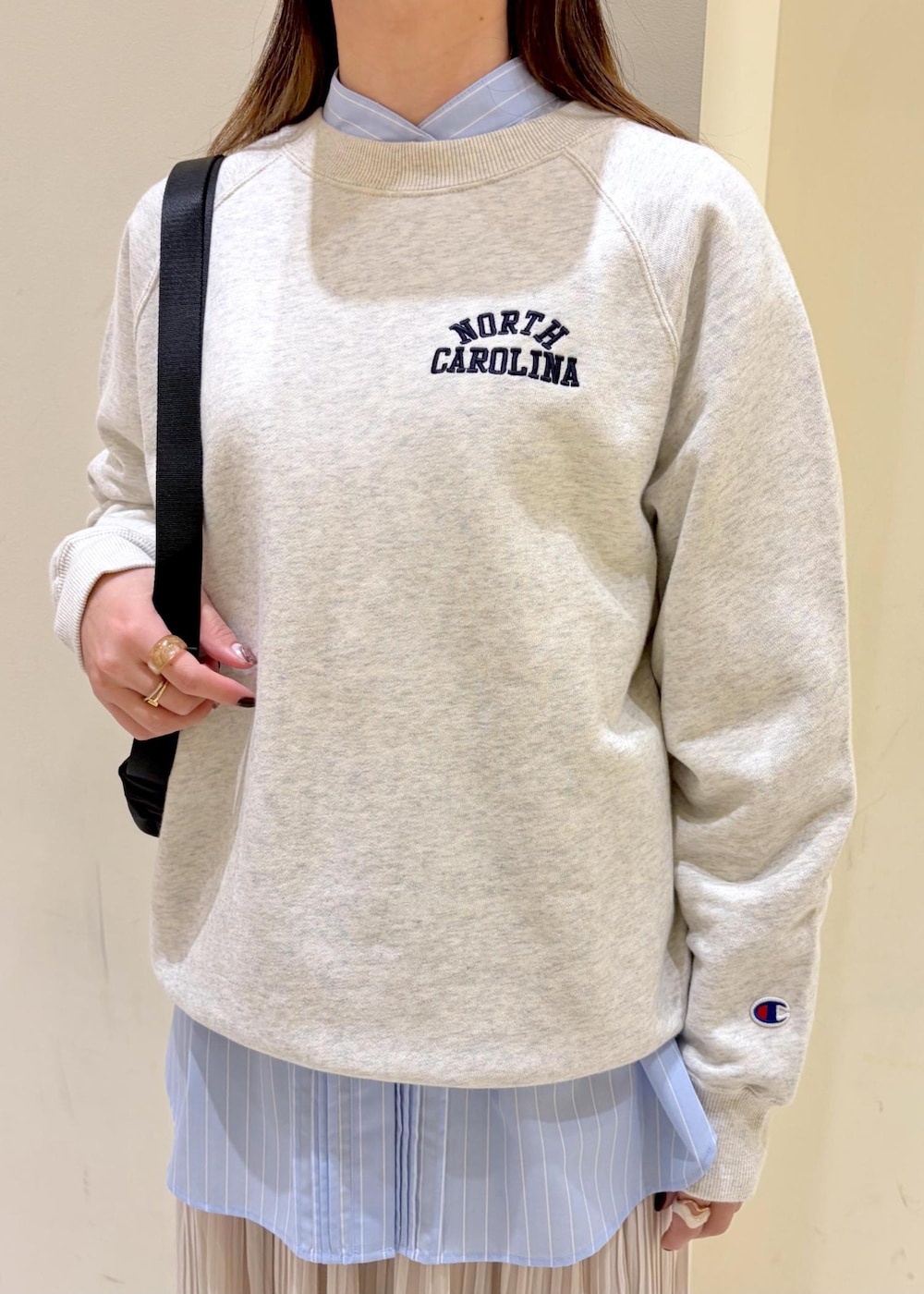 ホワイト系のスウェット、ブルー系のシャツ/ブラウス、ベージュ系のスカートを着用したレディースの冬コーディネートの5枚目の写真