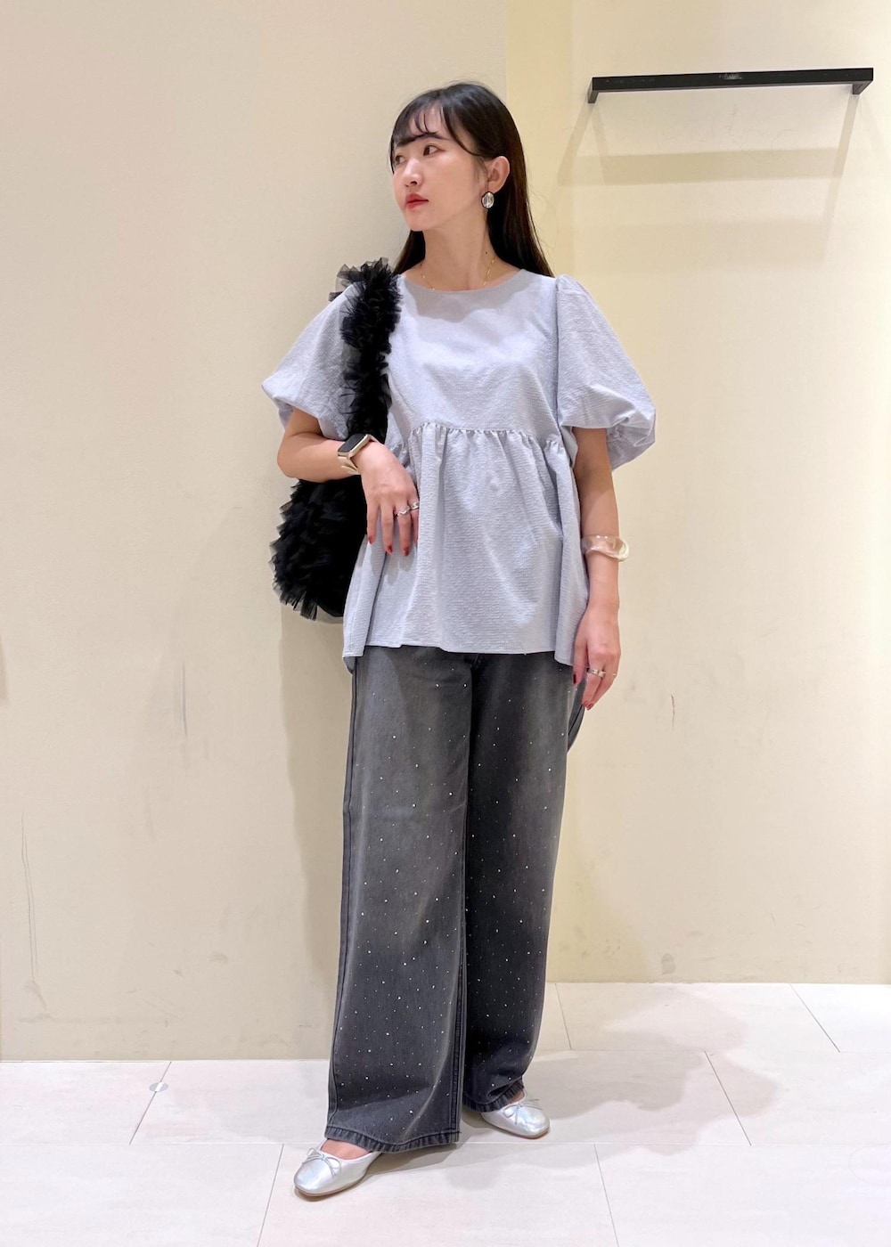 ブラック系のショルダーバッグ、シルバー系のバレエシューズ、ブルー系のシャツ/ブラウスを着用したレディースの夏コーディネートの2枚目の写真