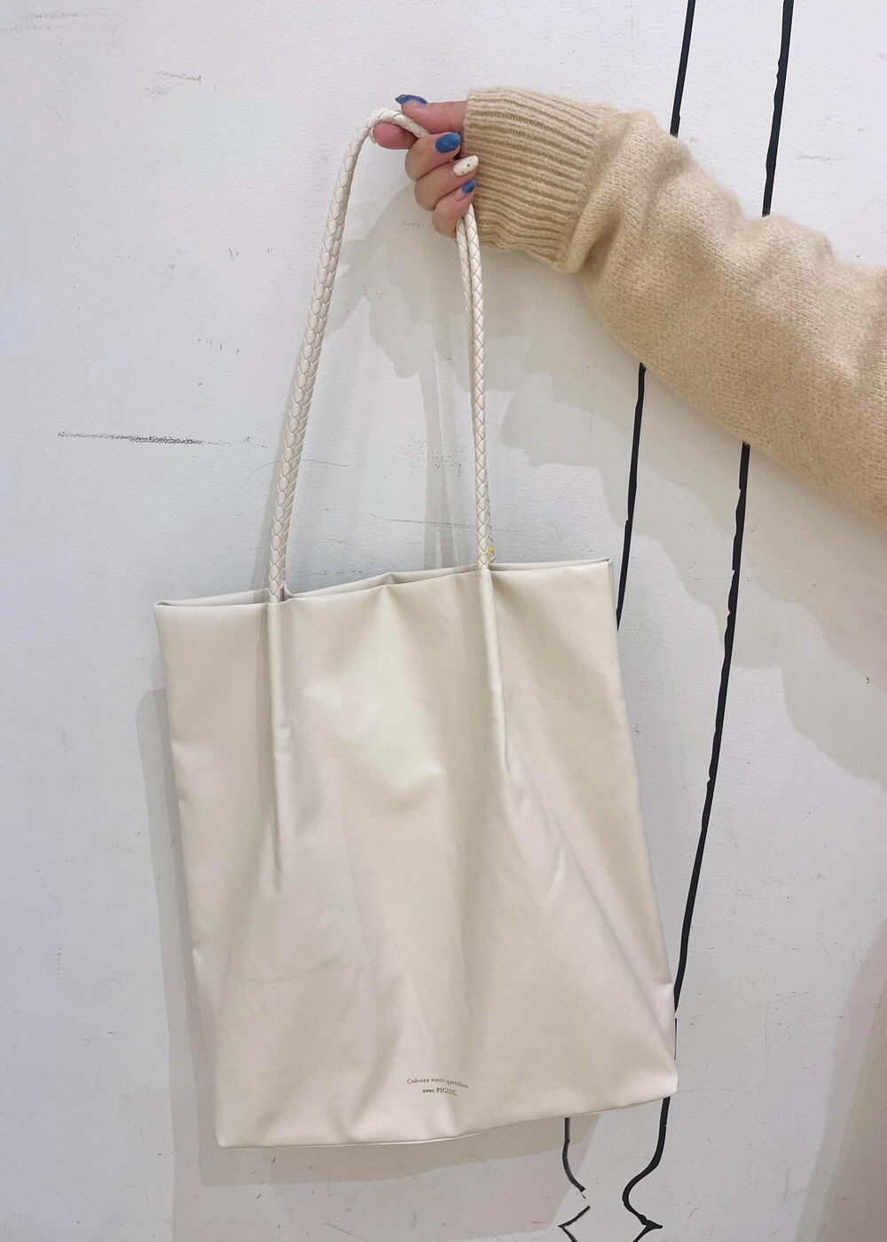 ホワイト系のトートバッグ、ブラック系のニット/セーター、ゴールド系のバレエシューズを着用したレディースの冬コーディネートの9枚目の写真