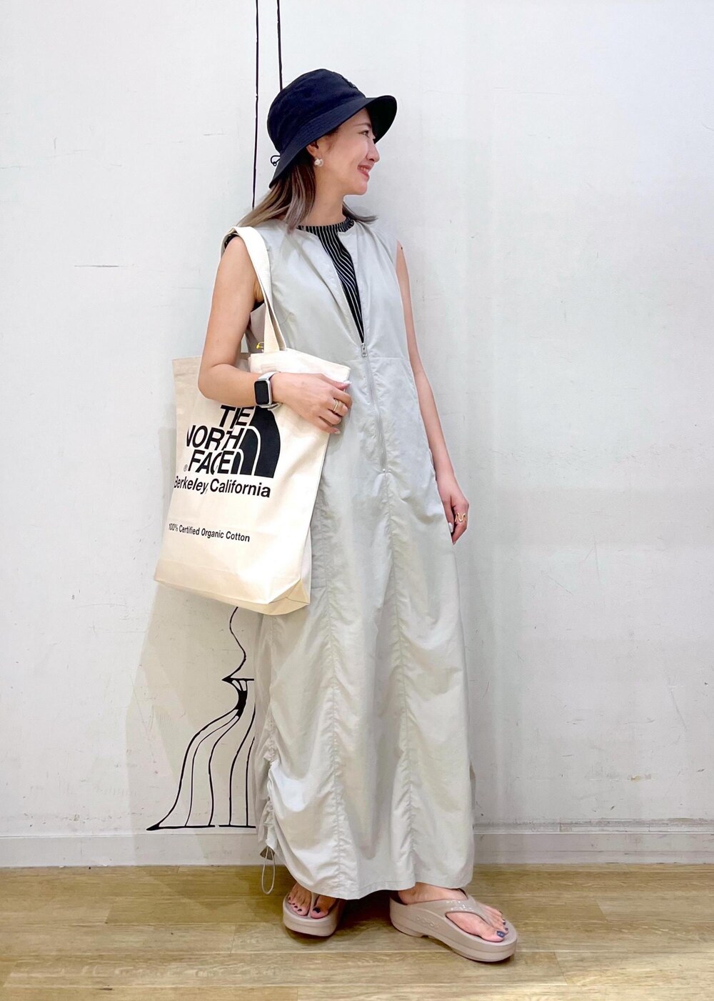 ホワイト系のトートバッグ、ブラック系のTシャツ/カットソー、グレー系のワンピースを着用したレディースの夏コーディネートの2枚目の写真