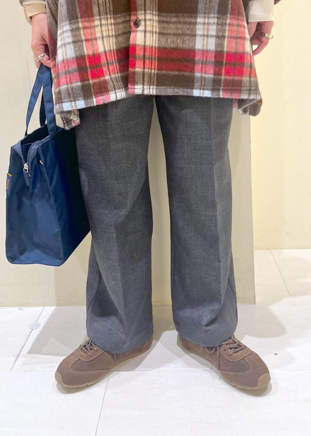 ブラウン系のシャツ/ブラウス、ホワイト系のニット/セーター、グレー系のスラックスを着用したレディースの冬コーディネートの8枚目の写真