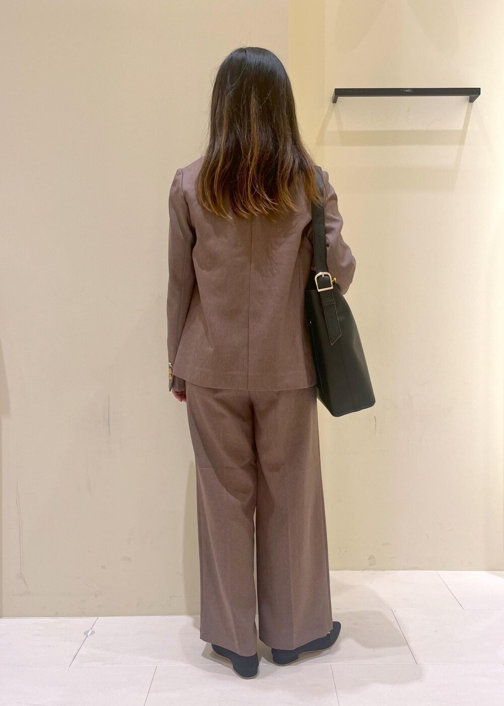 ブラック系のショルダーバッグ、ブラック系のシャツ/ブラウス、ベージュ系のテーラードジャケットを着用したレディースの秋コーディネートの3枚目の写真