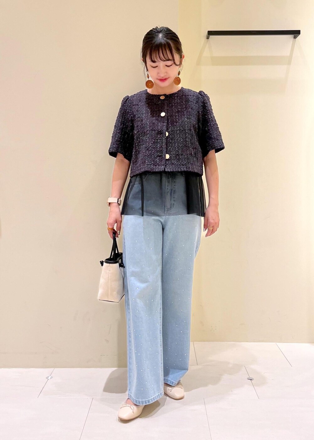 ブルー系のデニムパンツ、ホワイト系のバレエシューズ、グレー系のノーカラージャケットを着用したレディースの春コーディネートの2枚目の写真