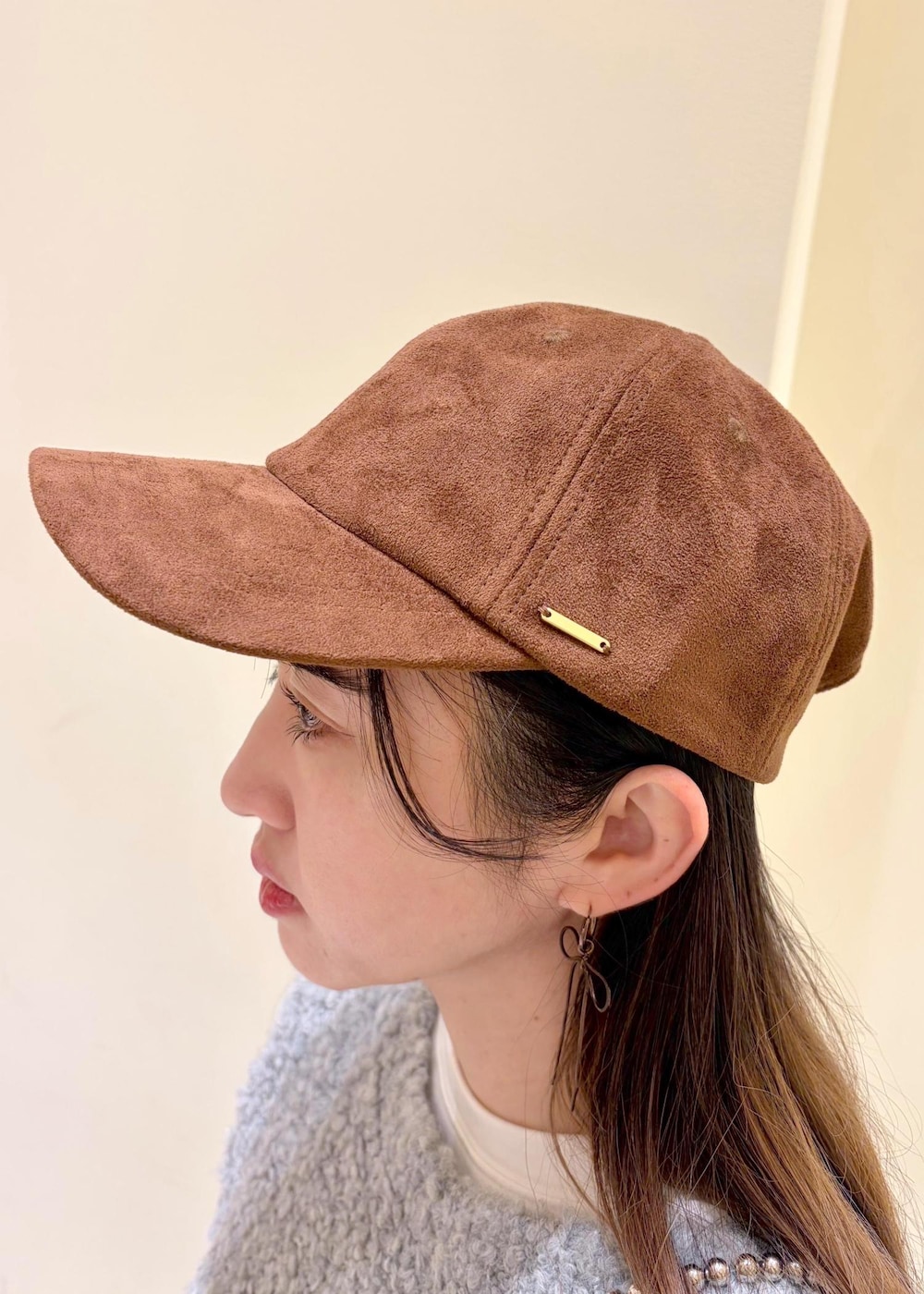 ブラック系のデニムパンツ、ブラウン系のブーツ、グレー系のニット/セーターを着用したレディースの冬コーディネートの4枚目の写真