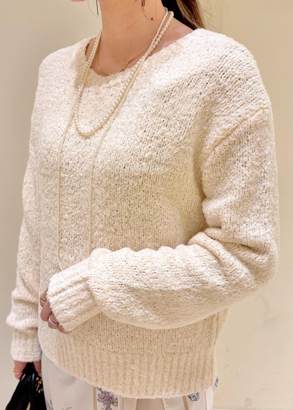 ブラック系のボストンバッグ、ベージュ系のその他パンツ、ホワイト系のニット/セーターを着用したレディースの冬コーディネートの5枚目の写真