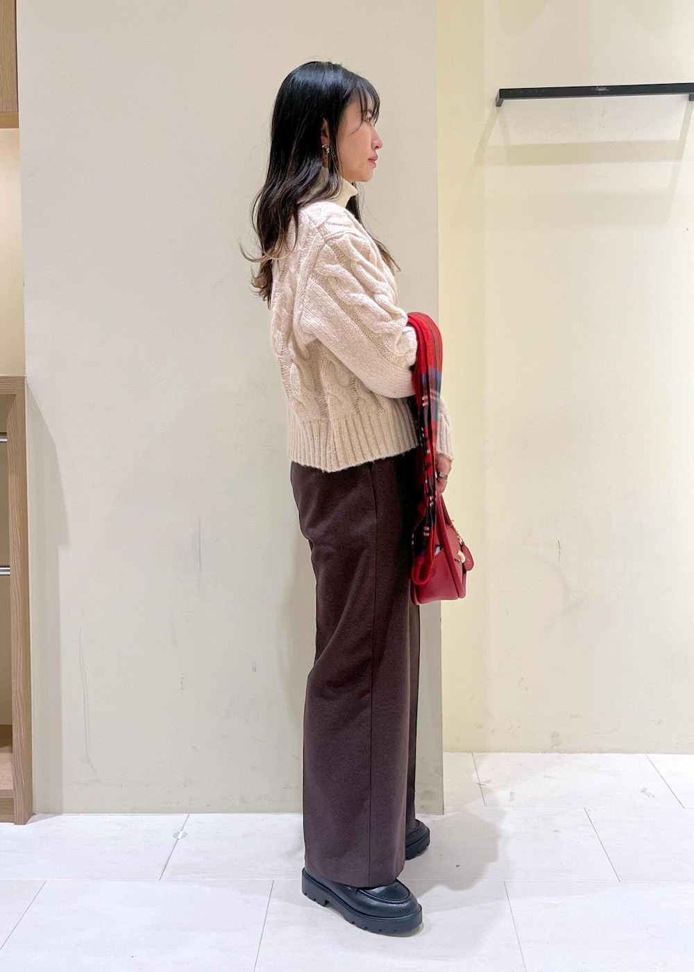 ホワイト系のニット/セーター、レッド系のショルダーバッグ、ブラック系のローファーを着用したレディースの冬コーディネートの2枚目の写真