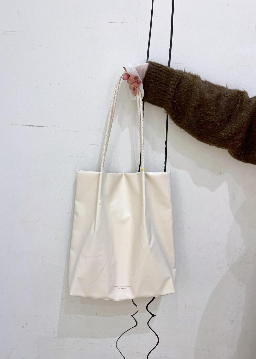 ブラック系のスカート、ブラック系のブーツ、ブラウン系のニット/セーターを着用したレディースの秋コーディネートの8枚目の写真