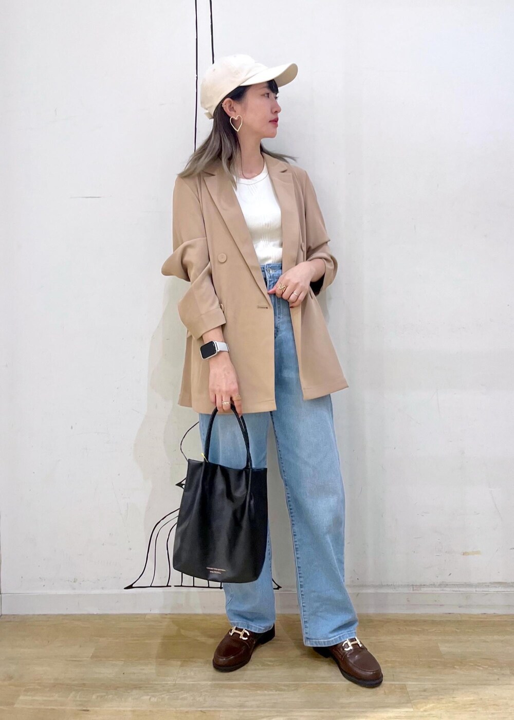 ブラウン系のローファー、ブラック系のトートバッグ、ブルー系のデニムパンツを着用したレディースの秋コーディネートの3枚目の写真
