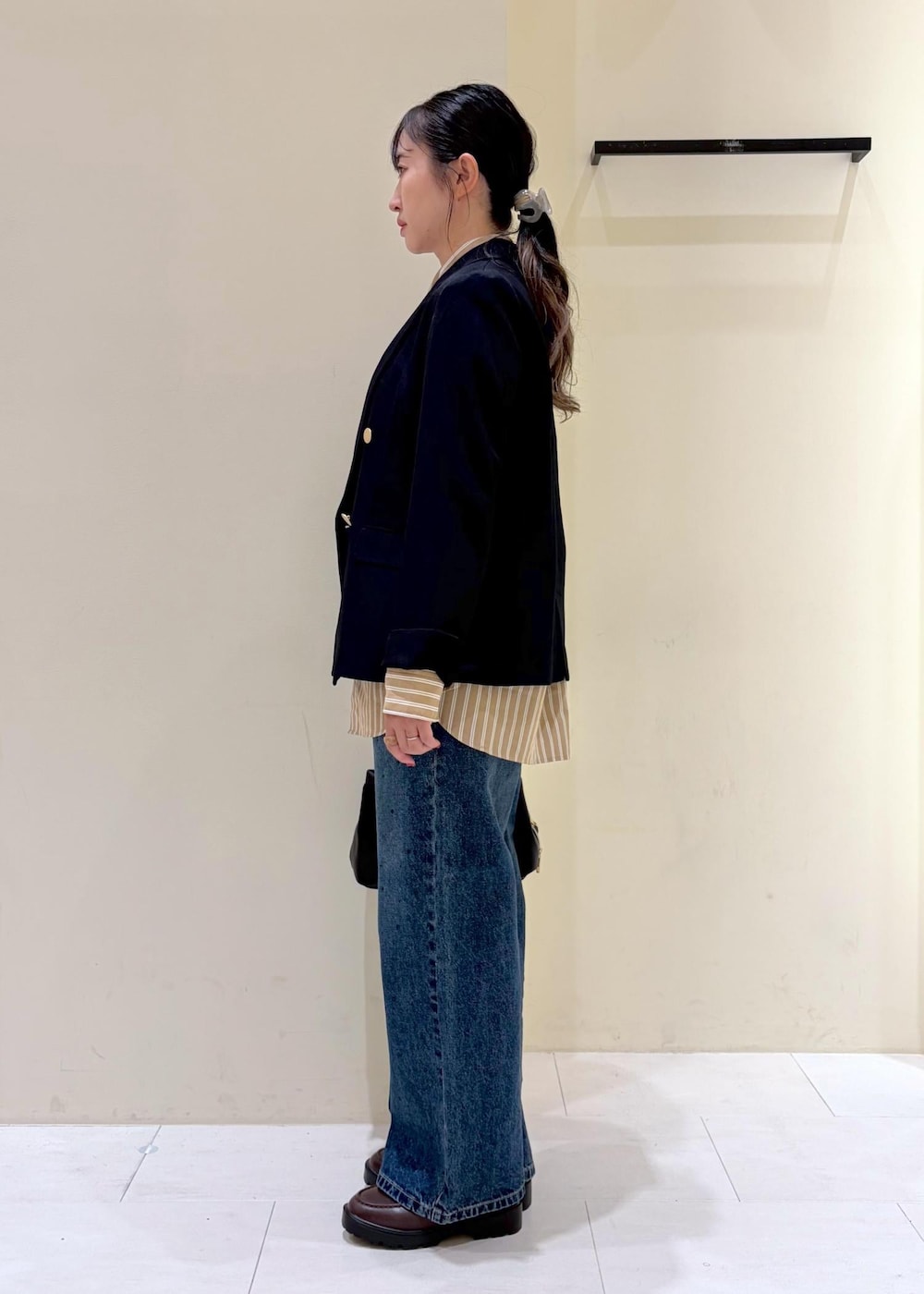 ブルー系のデニムパンツ、ブラウン系のローファー、ブラック系のトートバッグを着用したレディースの秋コーディネートの4枚目の写真