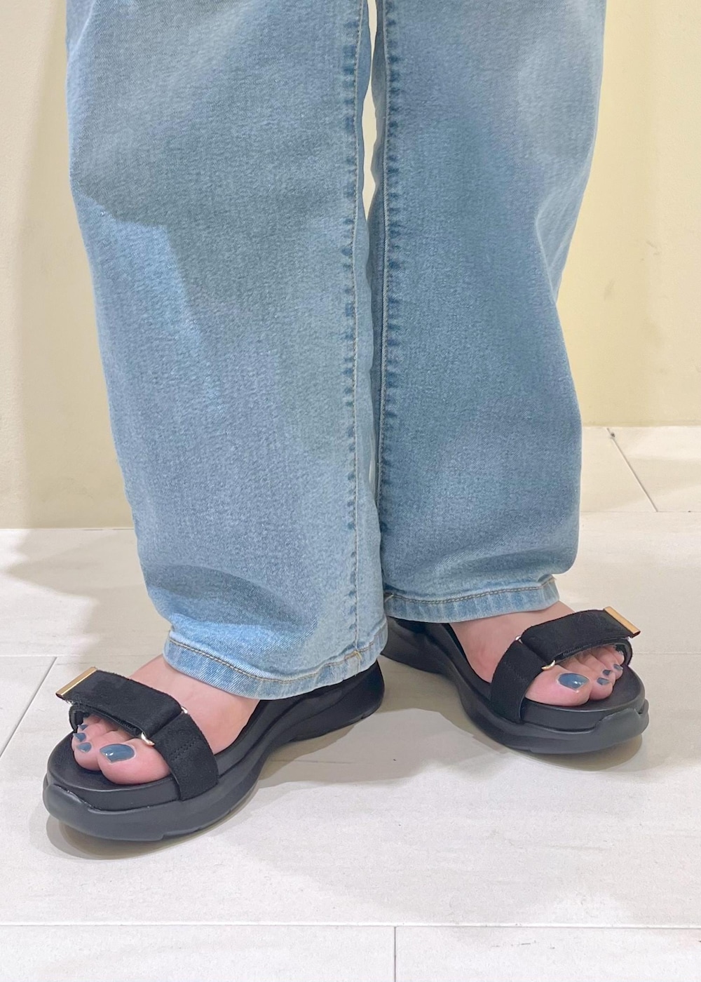 ブルー系のデニムパンツ、ブラック系のサンダル、ブラック系のバックパック/リュックを着用したレディースの夏コーディネートの10枚目の写真