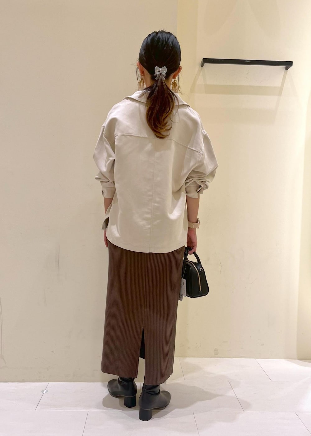 ベージュ系のシャツ/ブラウス、ブラック系のブーツ、グリーン系のスカートを着用したレディースの秋コーディネートの3枚目の写真